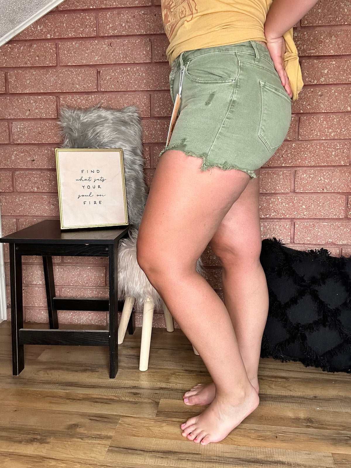 Side View. Risen Mid Rise Distressed Olive Shorts-29eleven | Women’s Fashion Boutique in Menan, Idaho